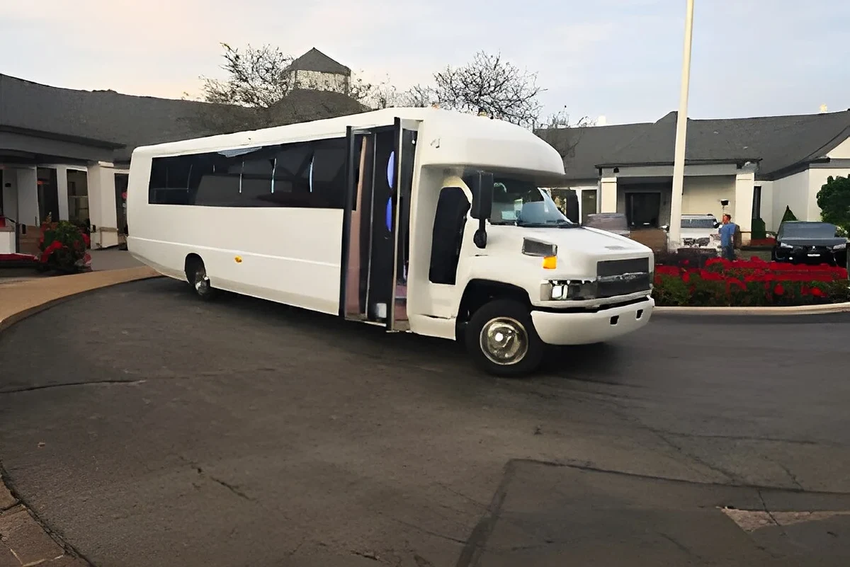White party bus parked at a venue entrance